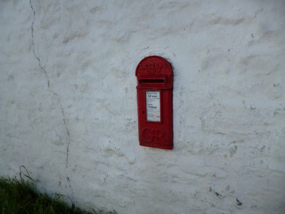 a little red postbox on a white wall