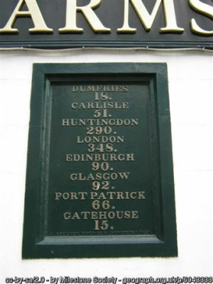 Old Milestone by the A713, King Street, Castle Douglas, Kelton Parish<br />By the A75, in parish of Kelton (Stewartry District), let into the wall of the &quot;Douglas Arms&quot;, an old coaching inn.