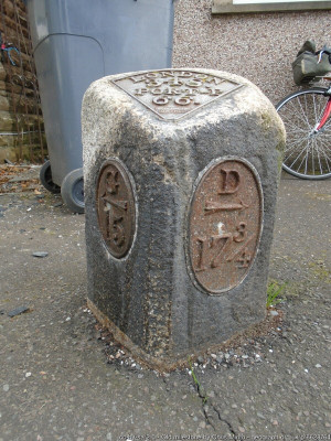 In Castle Douglas on the A713 at the north east end of the town near the A745 junction. Outside the National Farmers Union offices. This post is between Gatehouse of Fleet (G 15) and Dumfries (17¾) J Affleck's foundry was based in Maxwelltown on the west side of the River Nith near Dumfries. One of the Mail Trust posts which may explain why the mileage to London was important.