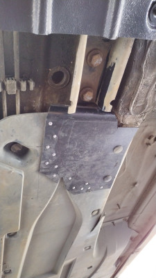 Undertray adjacent to exhaust tunnel - repaired with bin lid plastic and pop rivets