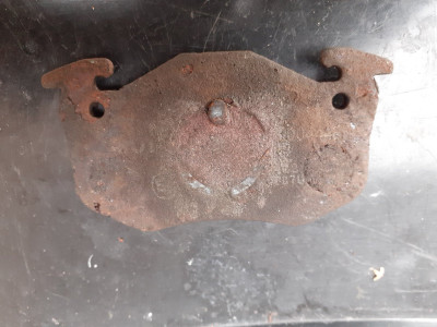 Old pads with witness marks showing irregular piston contact ie sat on the lug