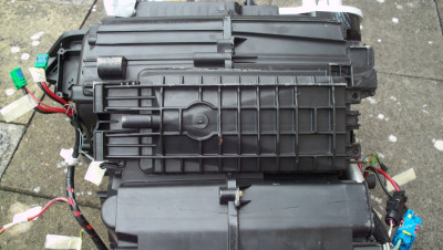 This is the underside of the heater unit showing the rectangular tray under the evaporator which collects the water. The hose (removed) attaches to the left.
