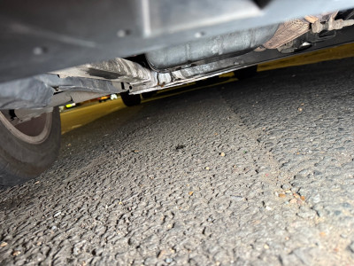Behind the oil pan
